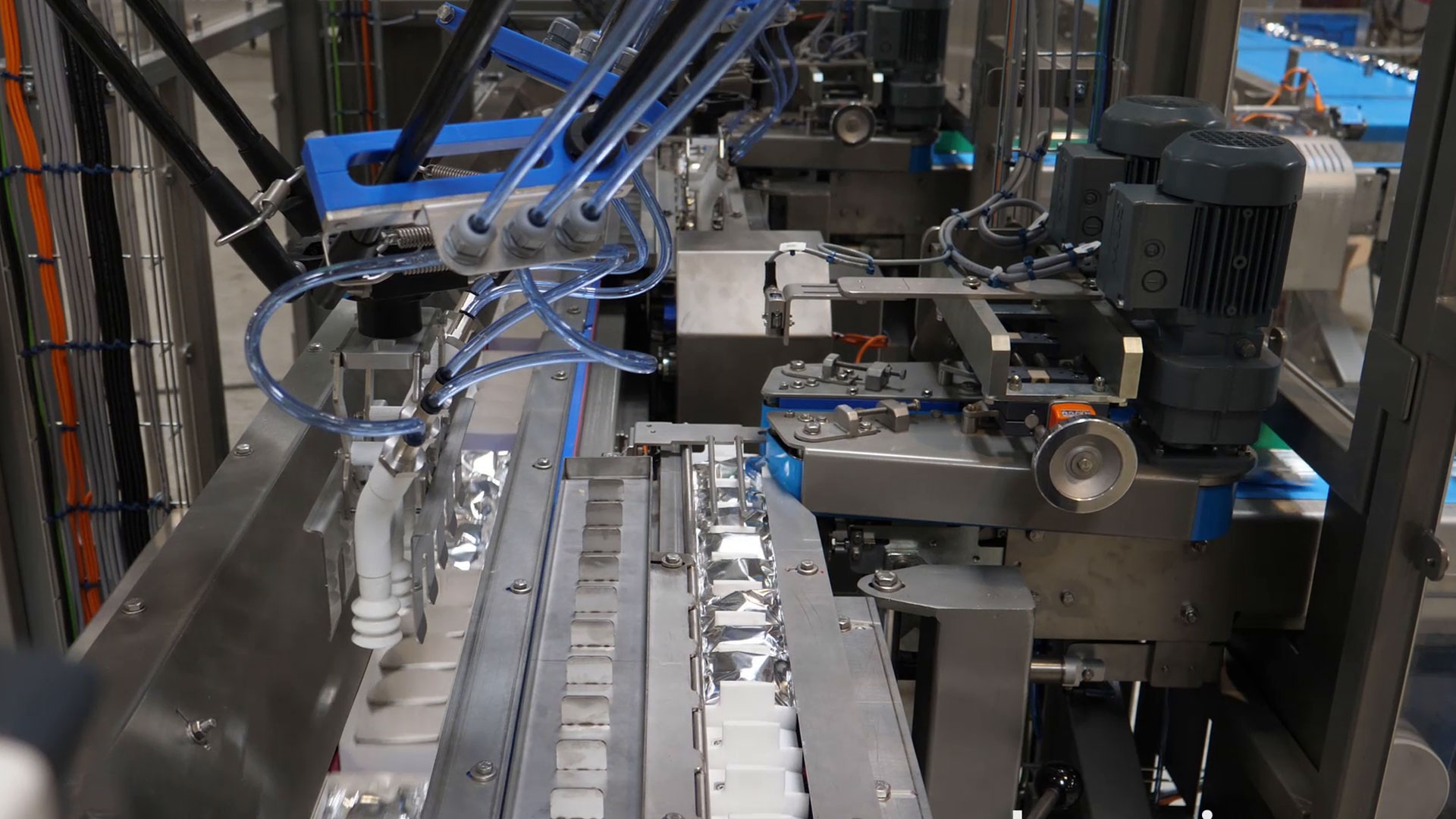 Robot station for packing machine in-feed
